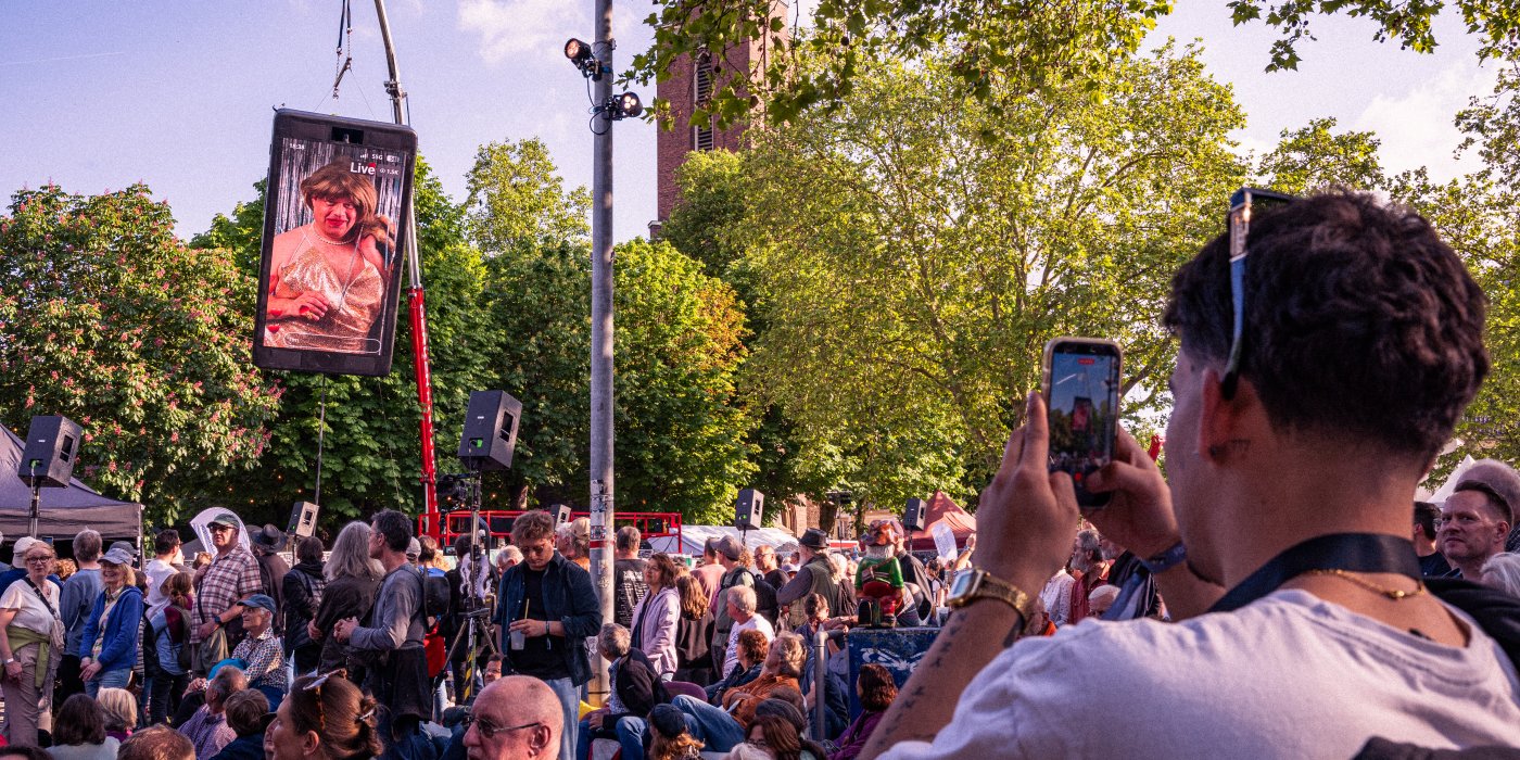 zuschauermenge sieht das haengende moersphone auf dem kapellplatz